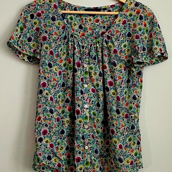 Pagina da colorare per bambini con fenicotteri e fiori nel giardino